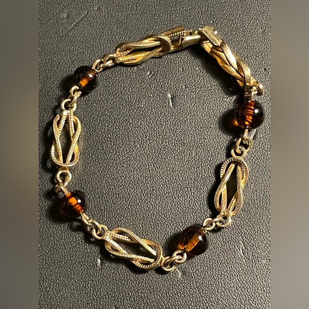 Vintage Avon On Clasp 1975 Love Knot Bracelet Gold tone   faux amber glass beads